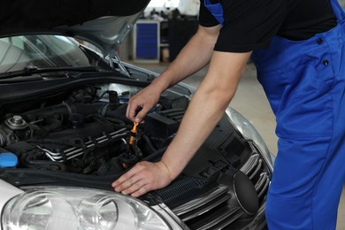 Photo of Auto mechanic fixing car at automobile repair shop, closeup