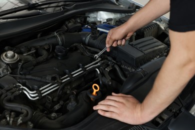 Photo of Auto mechanic fixing car at automobile repair shop, closeup