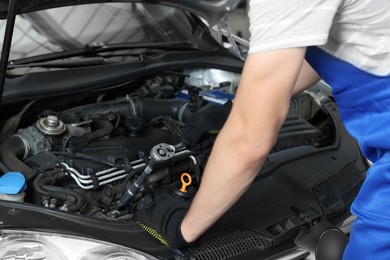 Photo of Auto mechanic fixing car at automobile repair shop, closeup