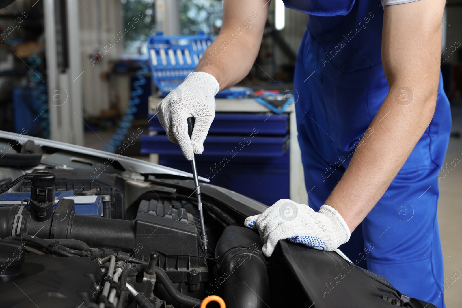 Photo of Auto mechanic fixing car at automobile repair shop, closeup