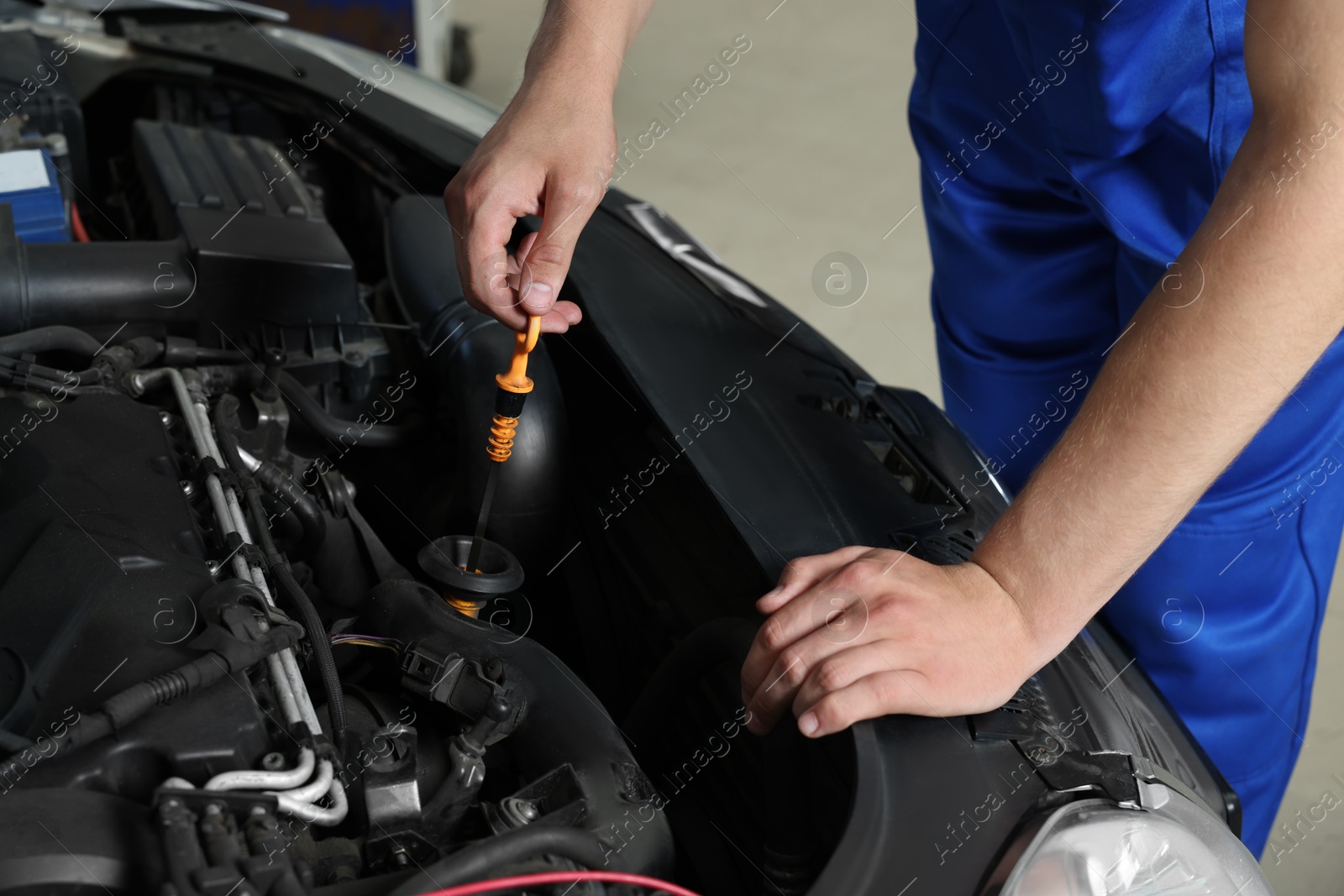 Photo of Auto mechanic fixing car at automobile repair shop, closeup