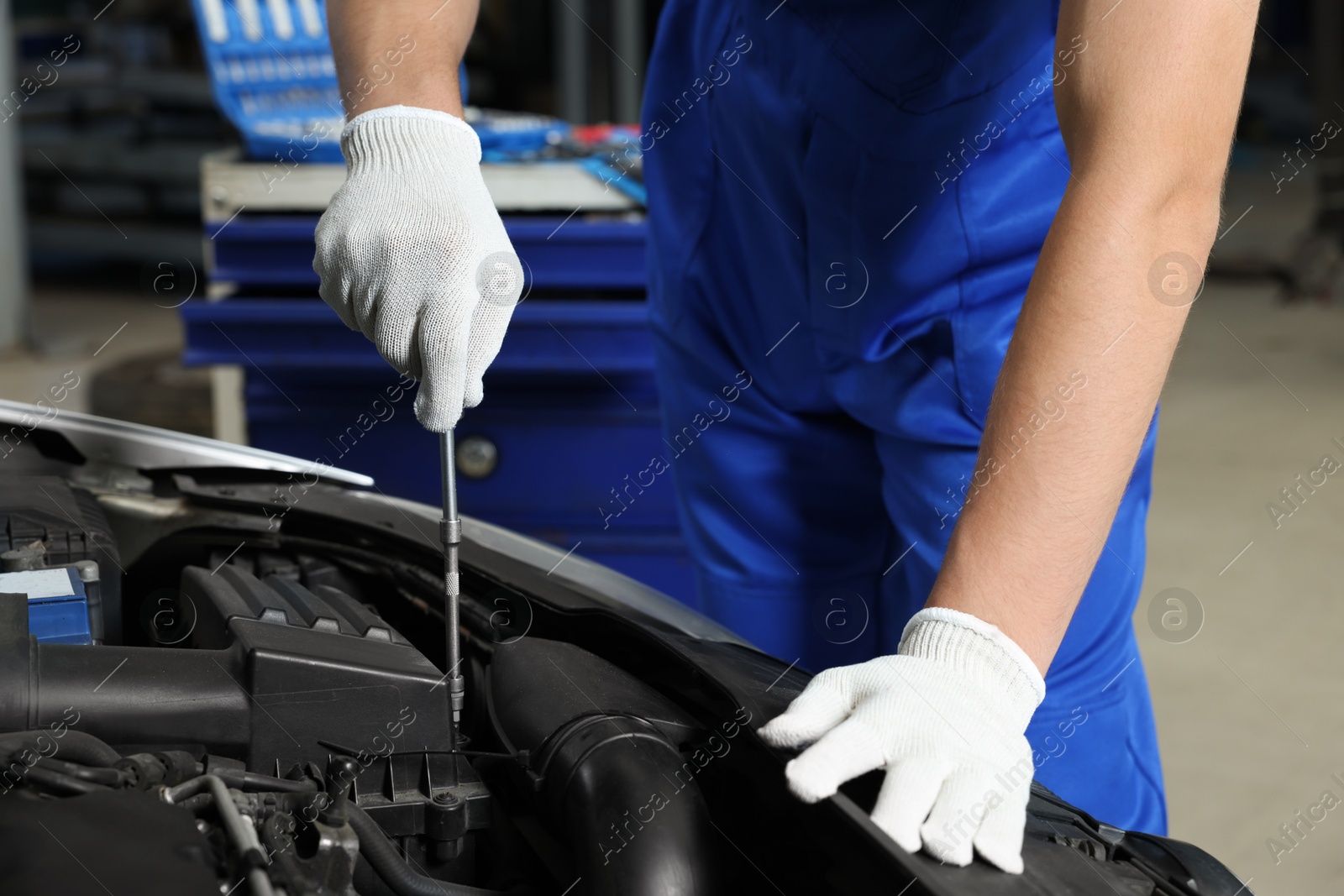 Photo of Auto mechanic fixing car at automobile repair shop, closeup