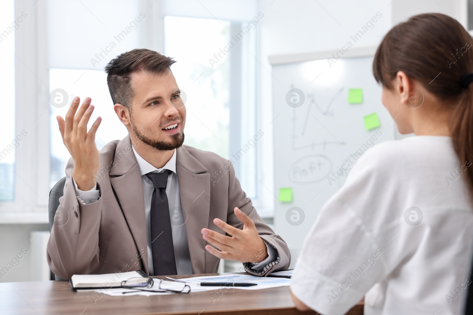 Photo of Consultant working with client at table in office. Business meeting