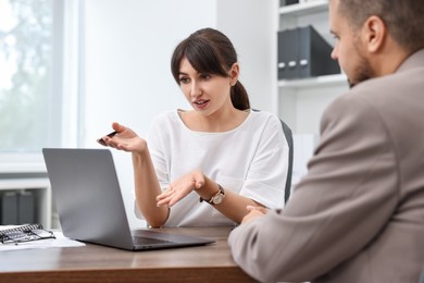 Consultant working with client at table in office. Business meeting