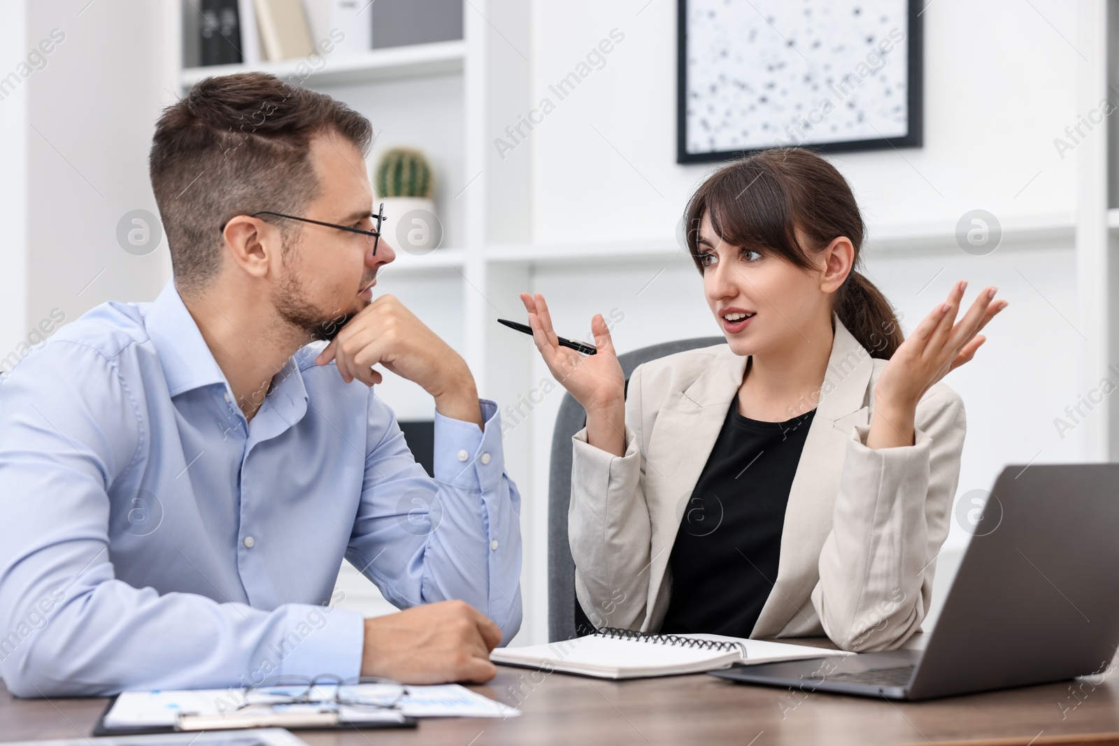 Photo of Consultant working with client at table in office. Business meeting