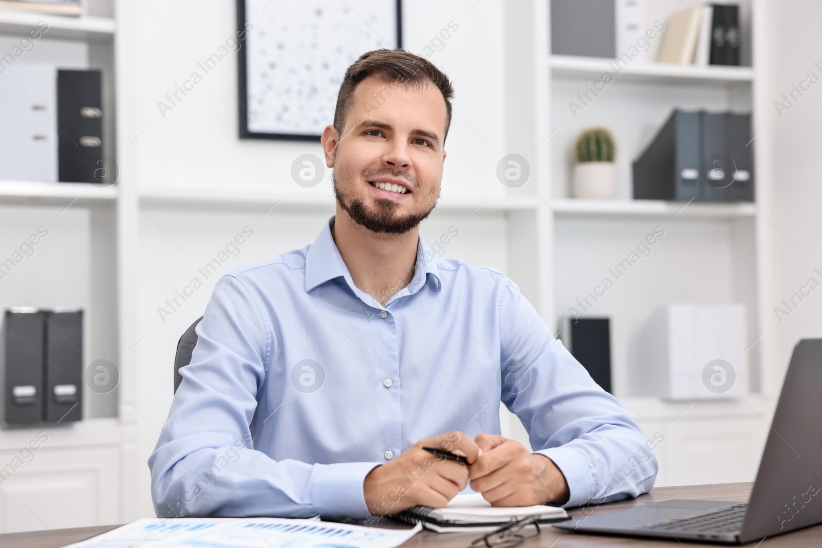 Photo of Portrait of smiling business consultant at table in office