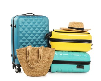 New suitcases, bag and straw hat isolated on white