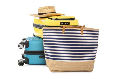 Photo of Bright suitcases with wicker hat and bag isolated on white