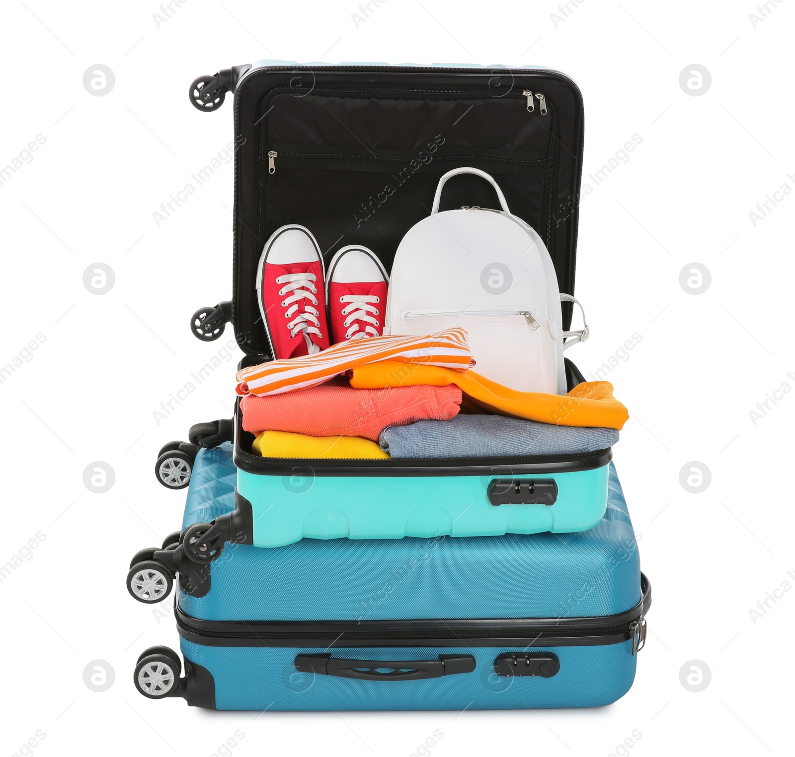 Photo of Bright suitcases with clothes, backpack and sneakers isolated on white