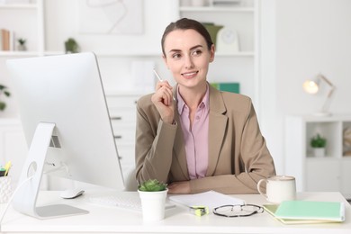 Photo of Smiling businesswoman working at table in office