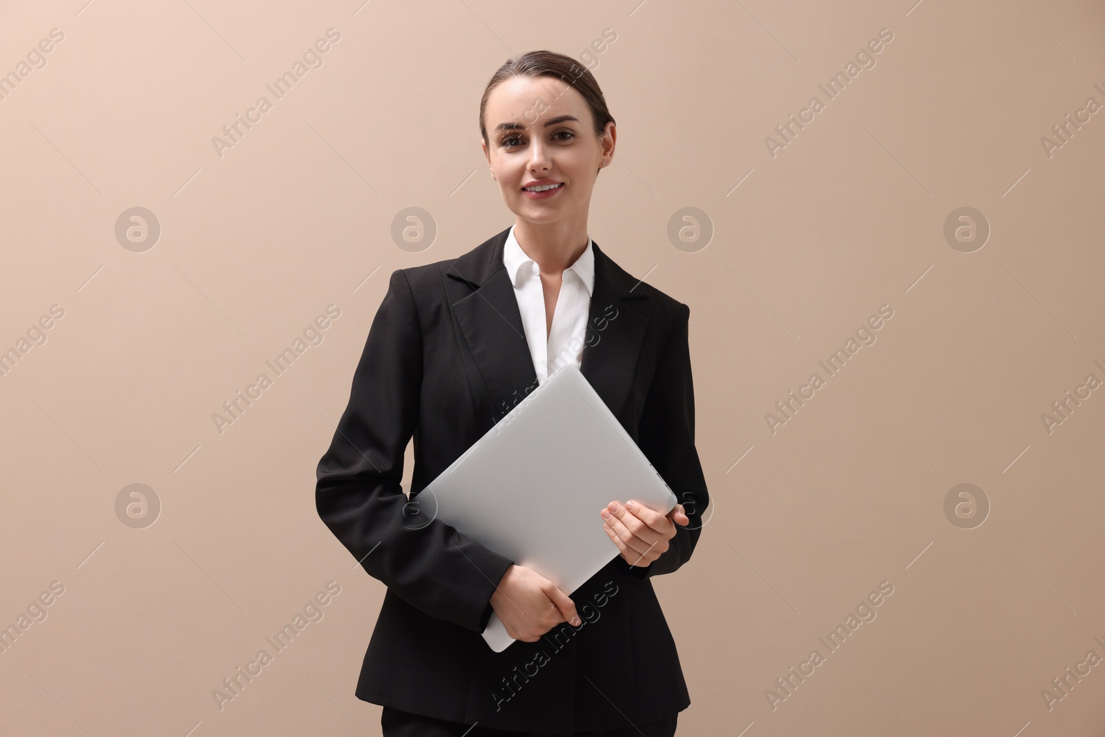 Photo of Portrait of smiling businesswoman with laptop on beige background