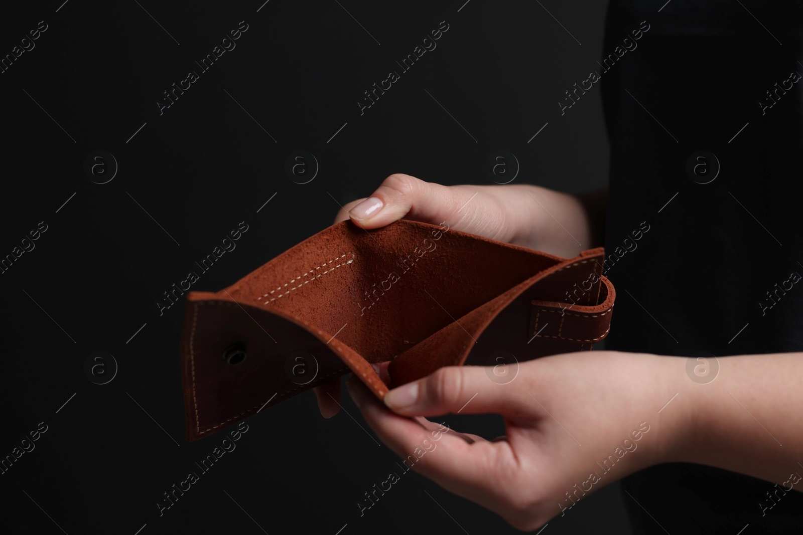 Photo of Woman with empty wallet on dark background, closeup