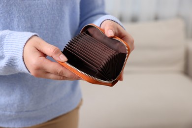 Photo of Woman with empty wallet indoors, closeup view