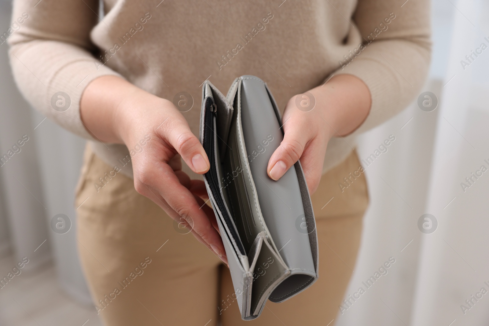 Photo of Woman with empty wallet indoors, closeup view