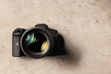 Modern photo camera on light grey table, top view. Space for text