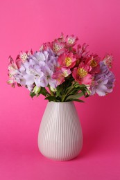 Beautiful alstroemeria flowers in vase on pink background