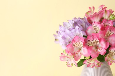 Photo of Beautiful alstroemeria flowers in vase on beige background, closeup. Space for text