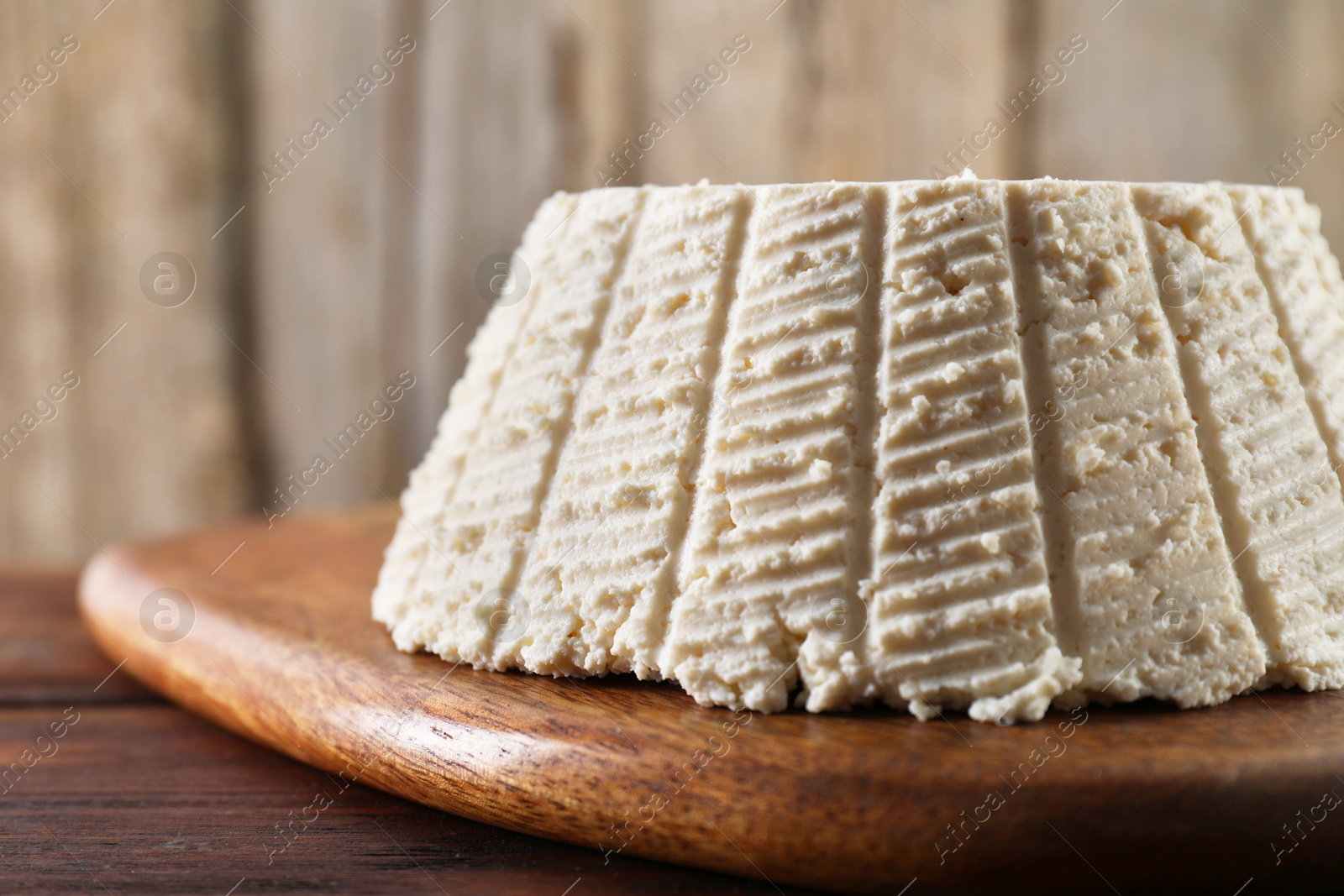 Photo of Tasty ricotta (cream cheese) on wooden table, closeup