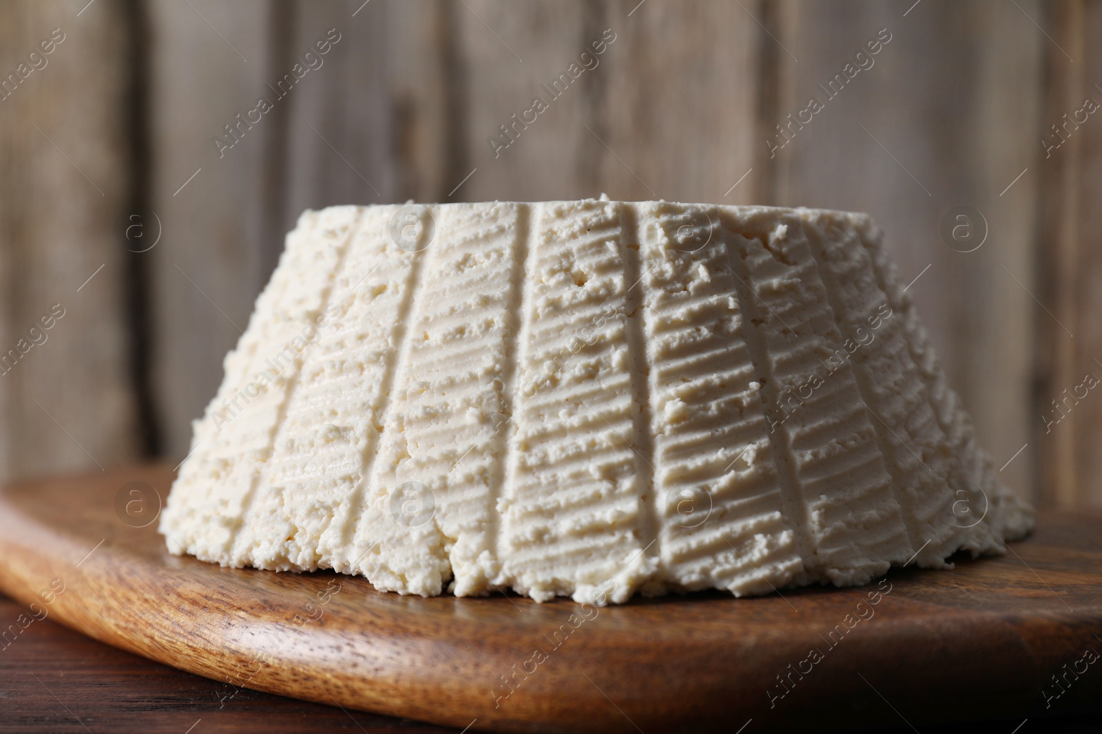 Photo of Tasty ricotta (cream cheese) on wooden table, closeup