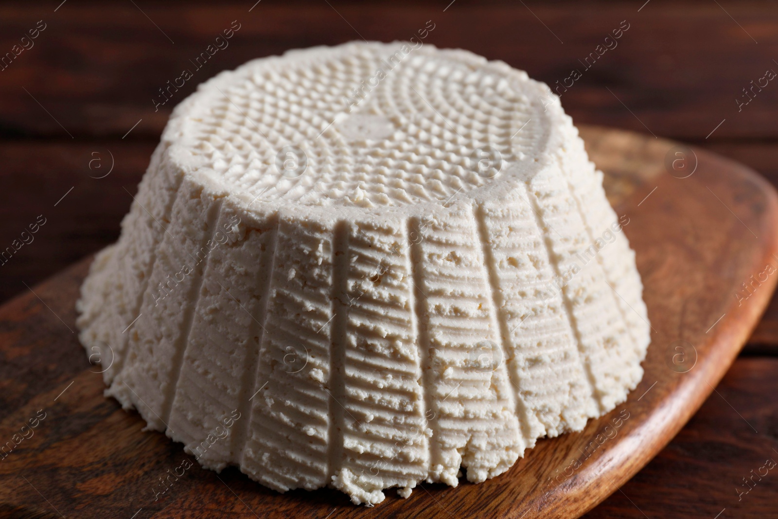 Photo of Tasty ricotta (cream cheese) on wooden table, closeup