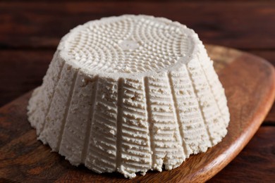 Photo of Tasty ricotta (cream cheese) on wooden table, closeup