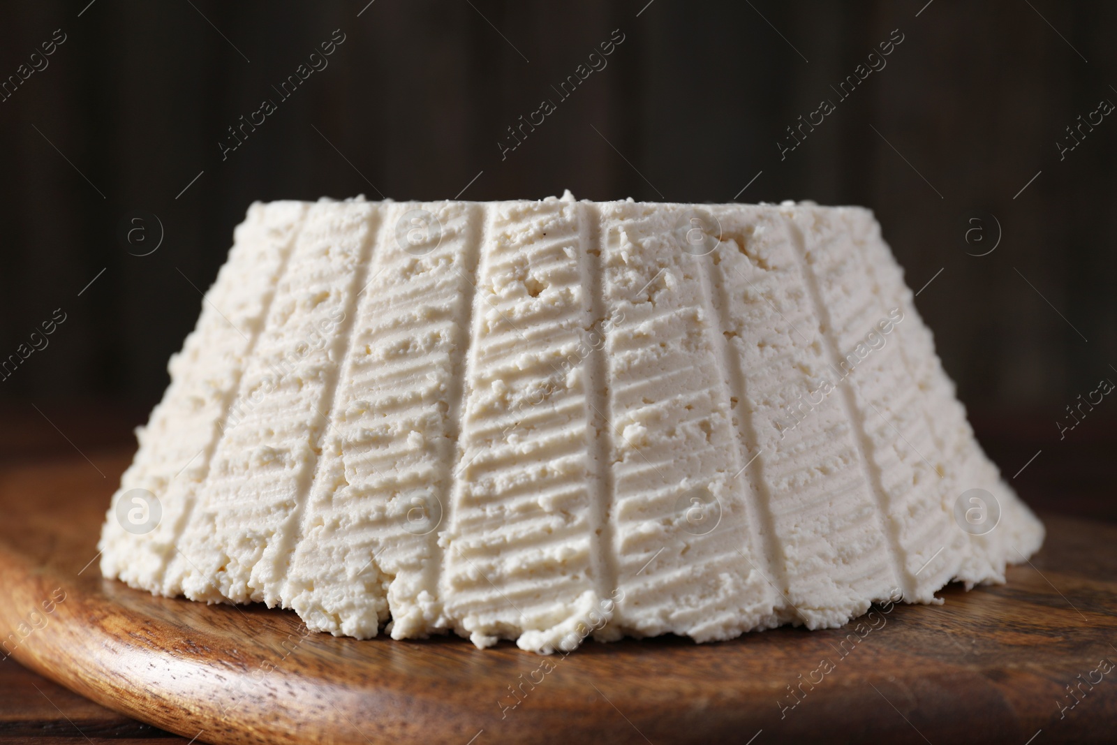 Photo of Tasty ricotta (cream cheese) on wooden table, closeup