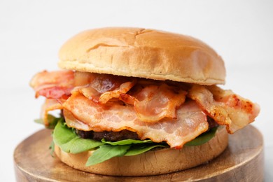 Photo of Delicious burger with bacon and greens on white background, closeup