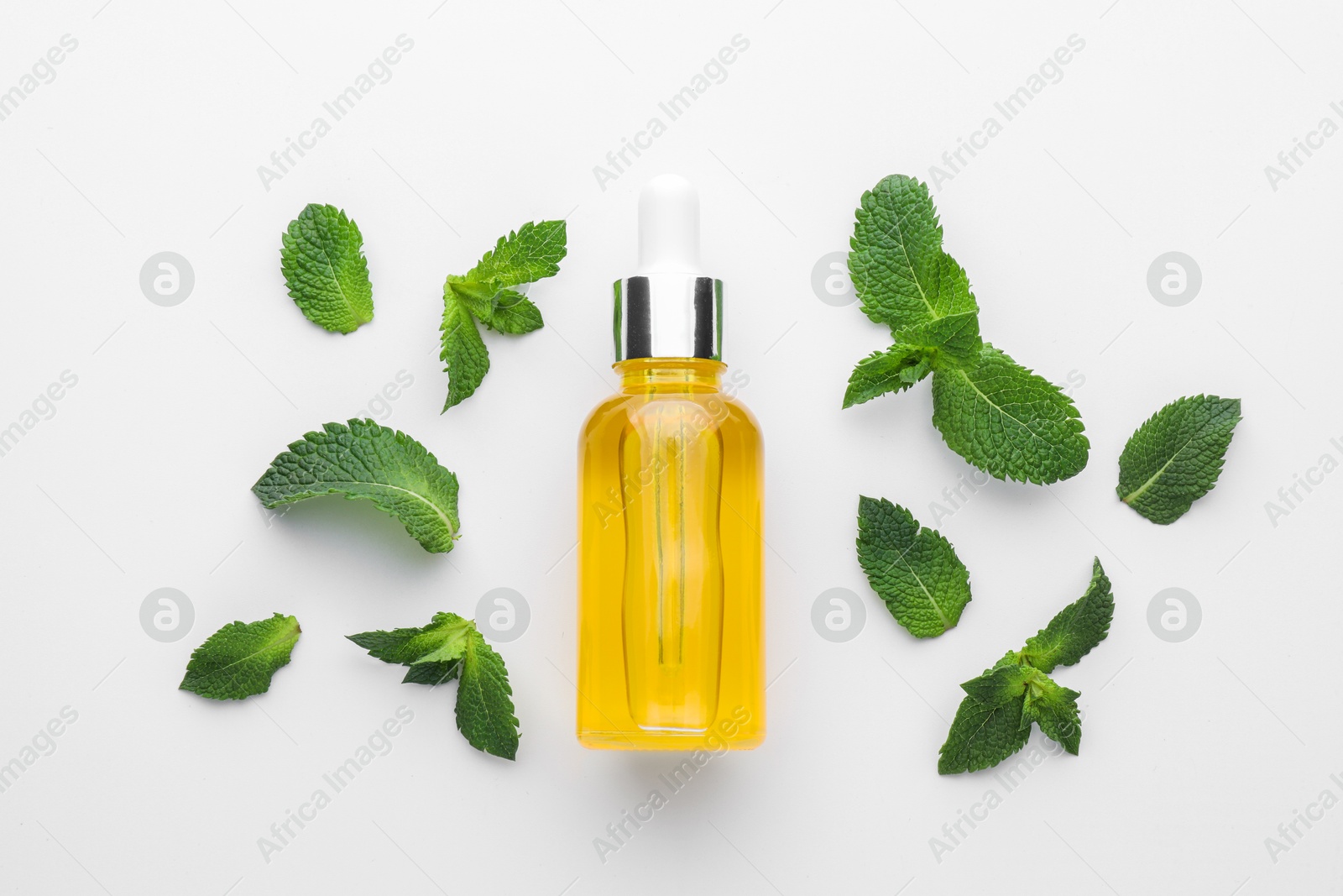 Photo of Bottle of essential oil and mint isolated on white, top view