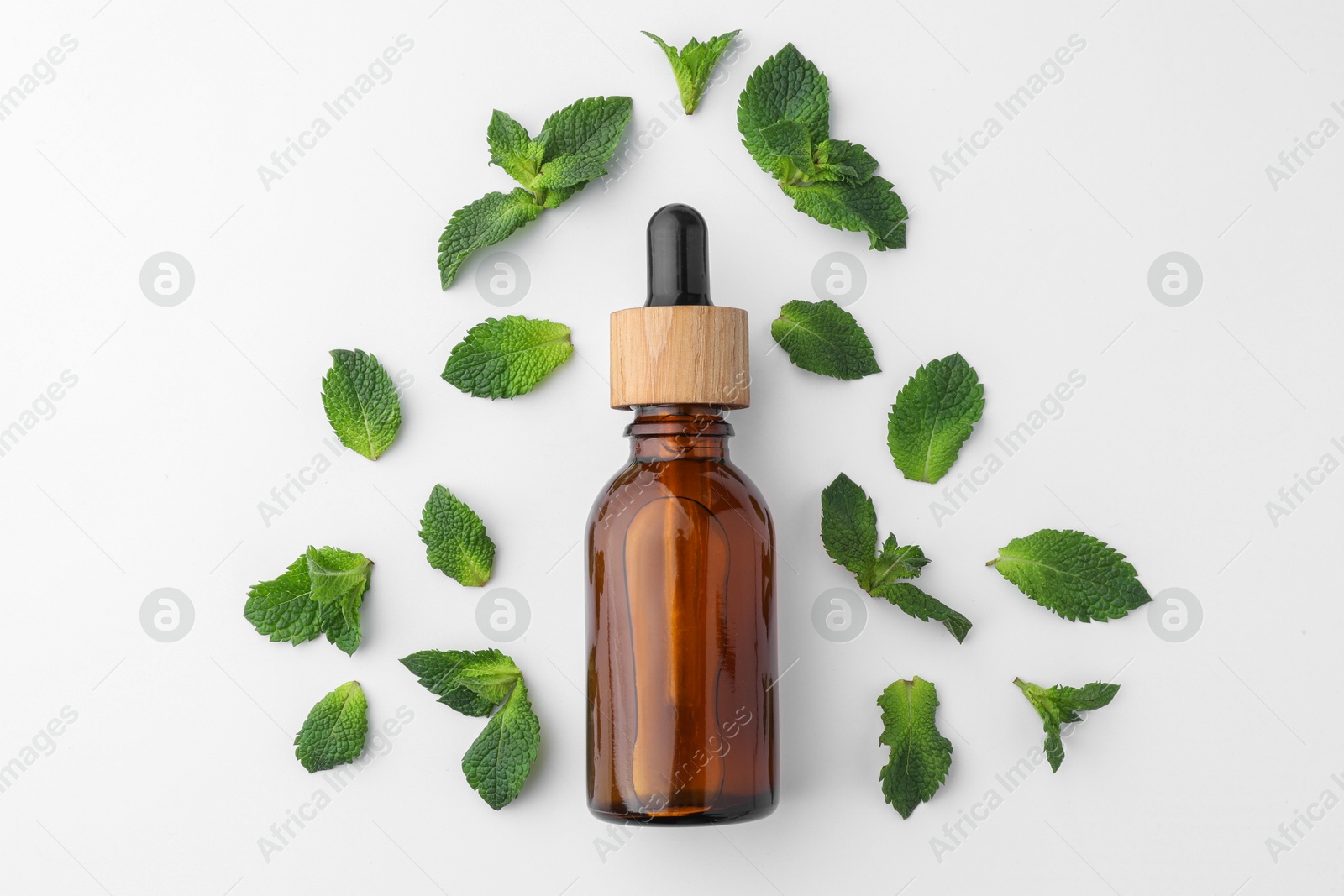 Photo of Bottle of essential oil and mint isolated on white, top view