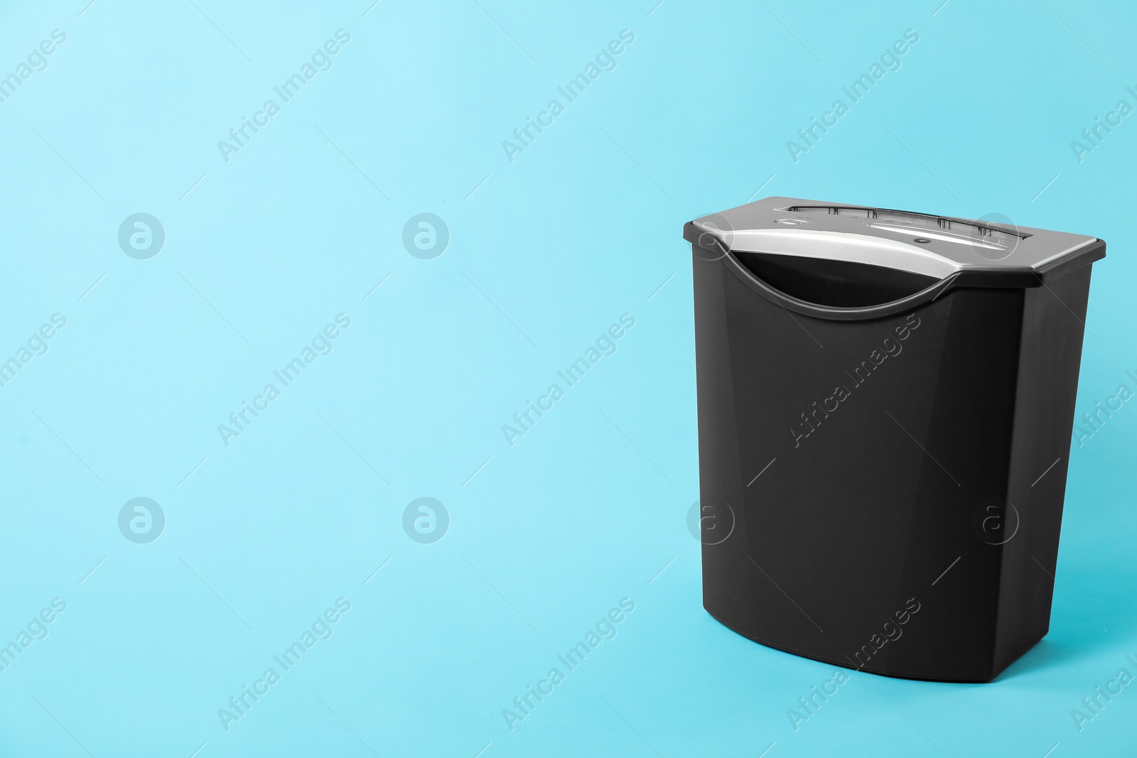 Photo of One paper shredder on light blue background, space for text