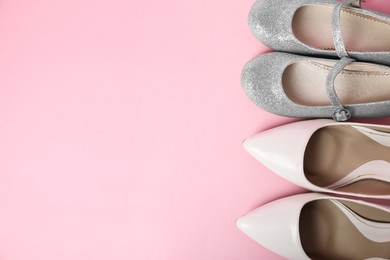 Photo of Big and small shoes on pink background, top view. Space for text