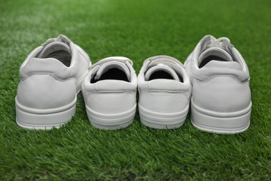 Photo of Big and small shoes on green grass