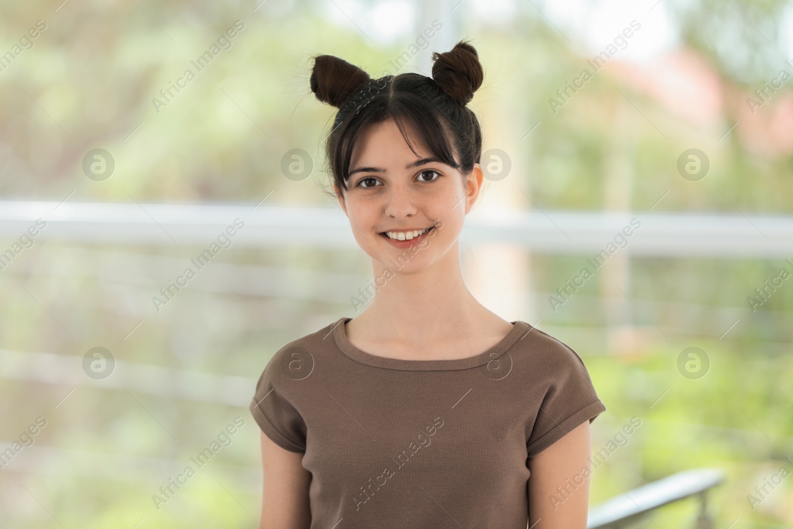 Photo of Portrait of smiling teenage girl on blurred background