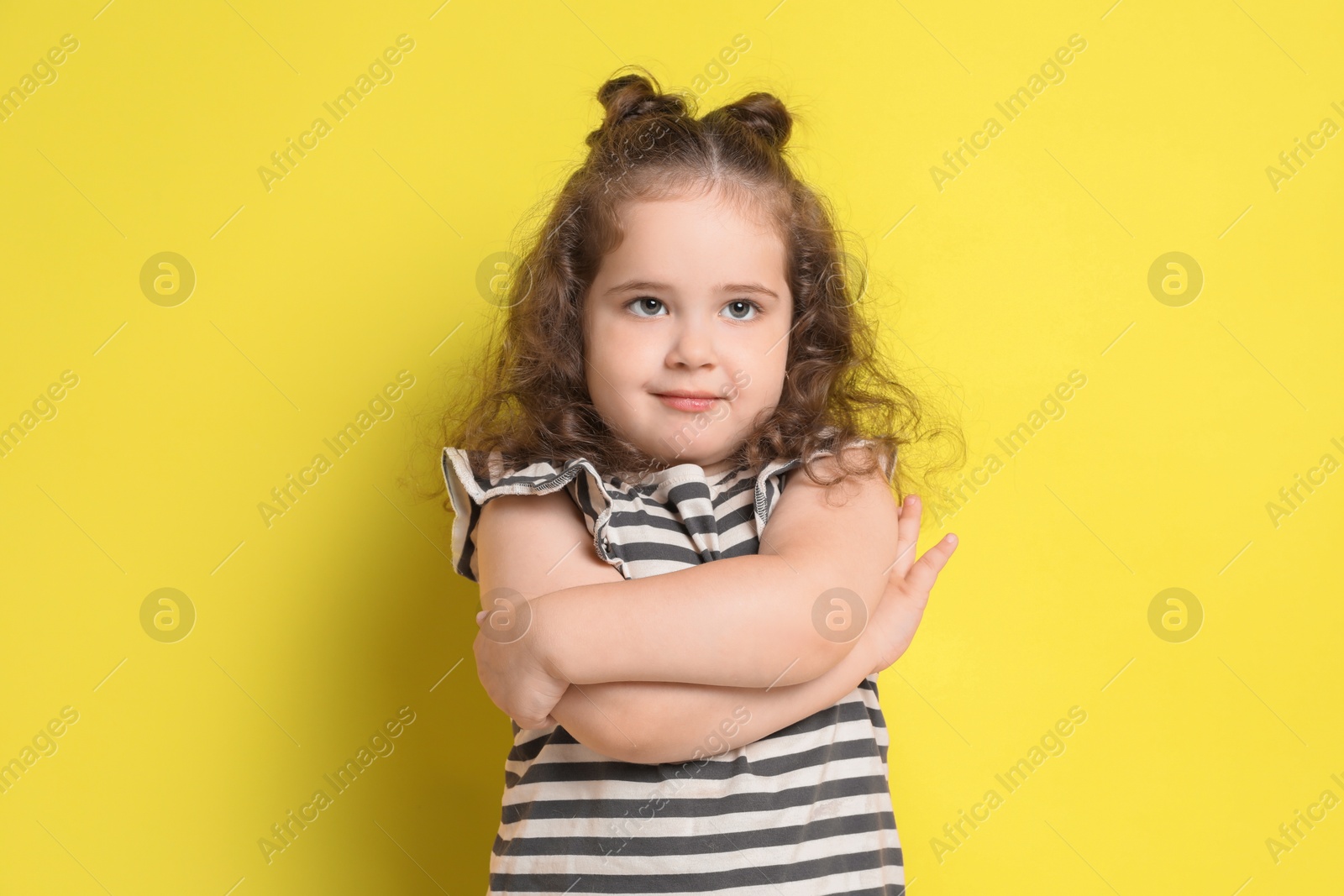 Photo of Portrait of cute girl on yellow background. Adorable child