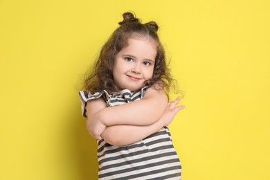 Photo of Portrait of cute girl on yellow background. Adorable child