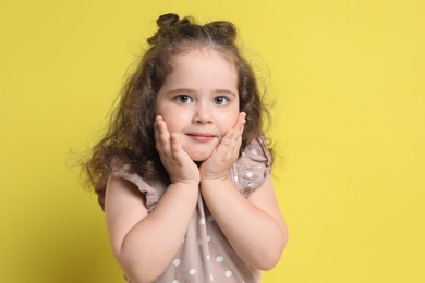 Photo of Portrait of cute girl on yellow background. Adorable child