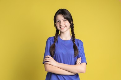 Photo of Portrait of smiling teenage girl on yellow background