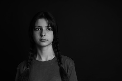 Photo of Portrait of teenage girl on dark background, space for text. Black and white effect