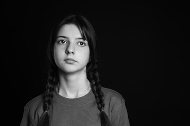 Photo of Portrait of teenage girl on dark background, space for text. Black and white effect