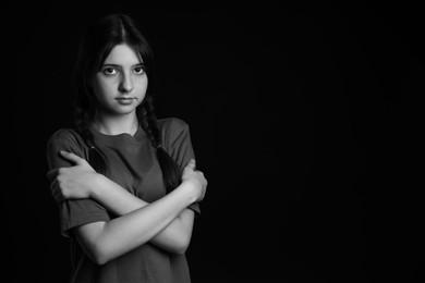 Photo of Portrait of teenage girl on dark background, space for text. Black and white effect