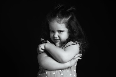 Portrait of emotional girl on dark background. Black and white effect