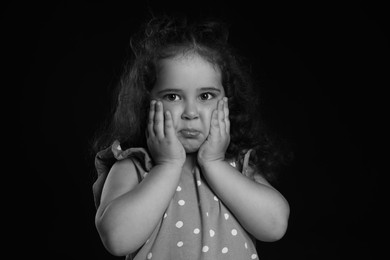 Photo of Portrait of emotional girl on dark background. Black and white effect