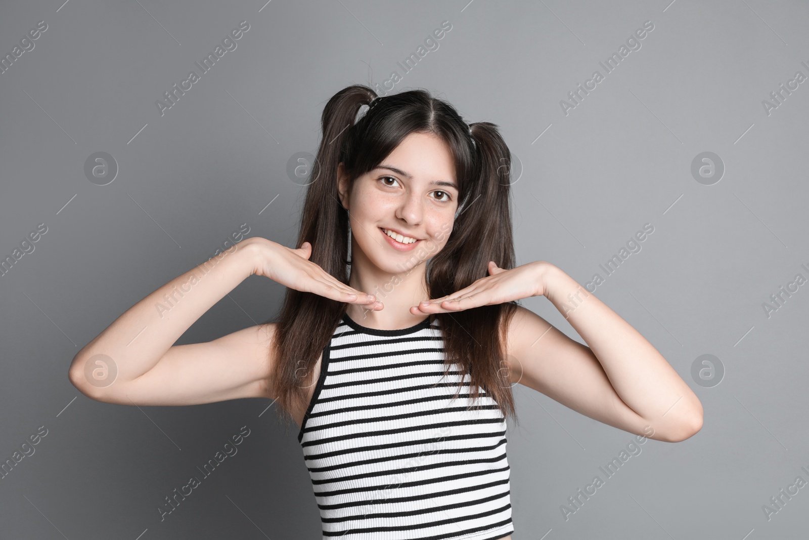 Photo of Portrait of smiling teenage girl on grey background