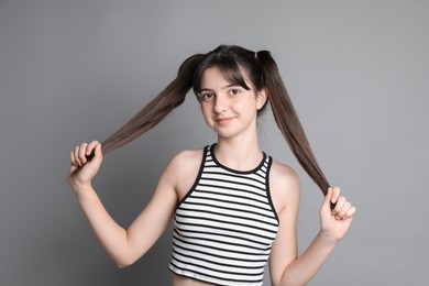 Portrait of cute teenage girl on grey background