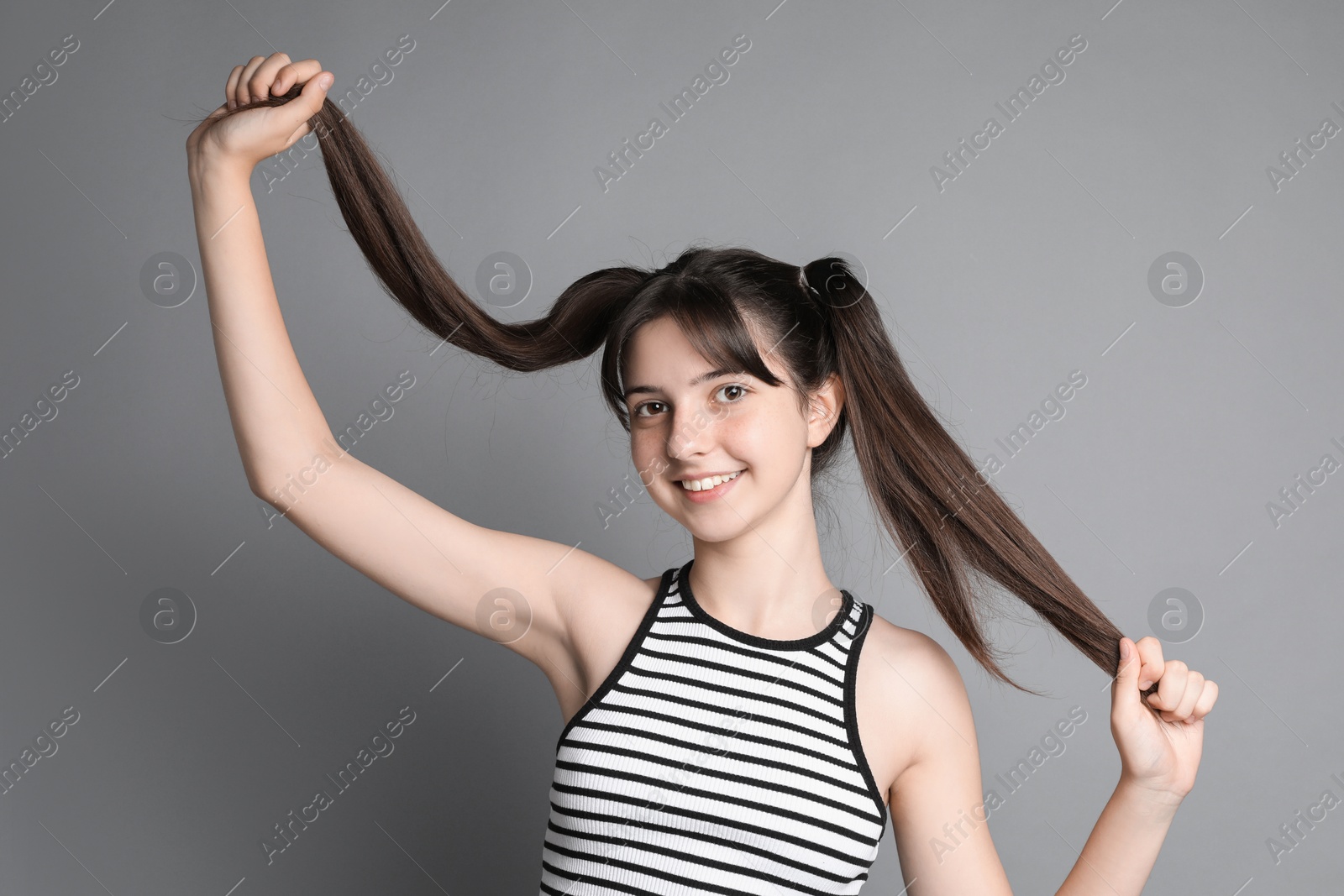 Photo of Portrait of smiling teenage girl on grey background