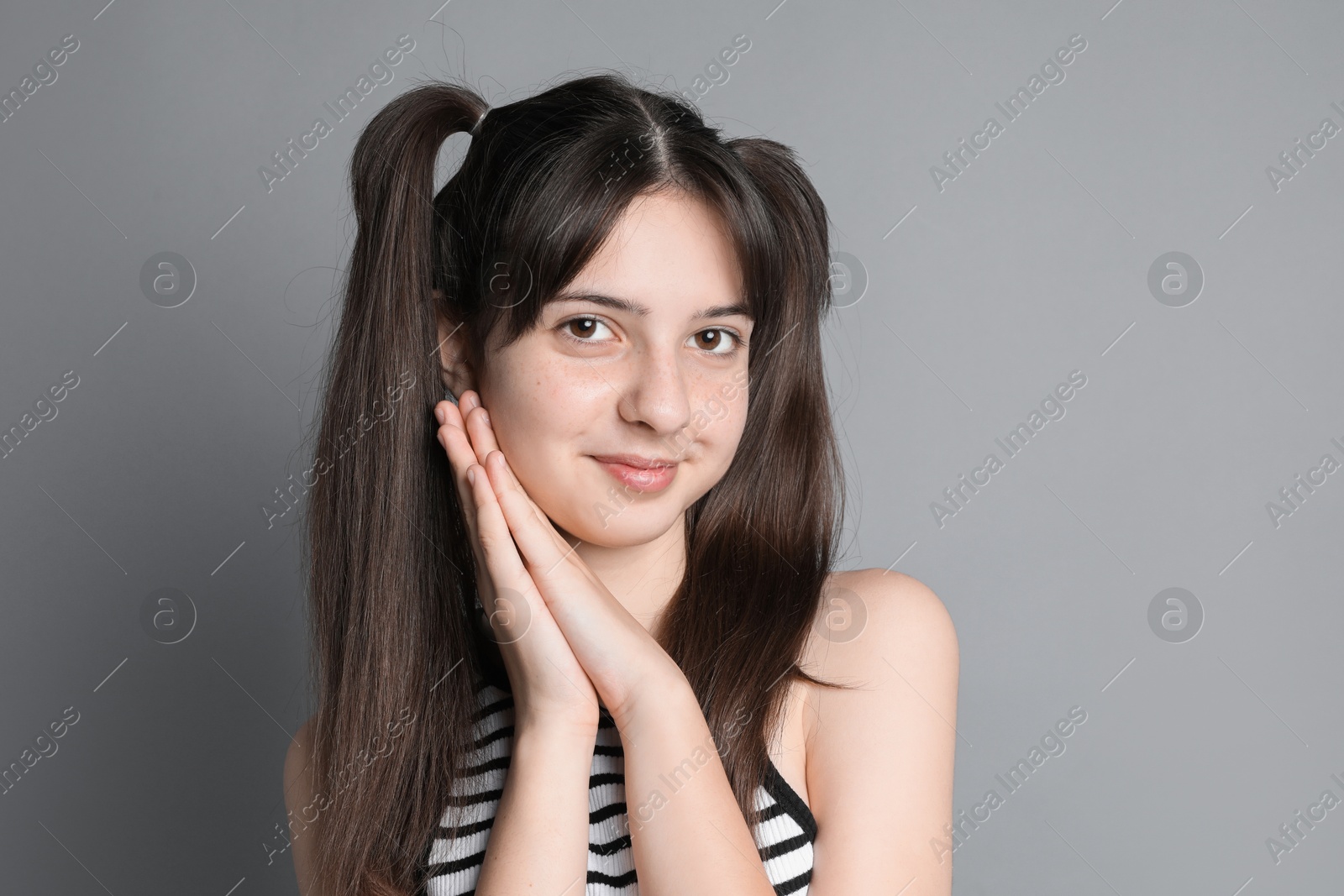 Photo of Portrait of cute teenage girl on grey background