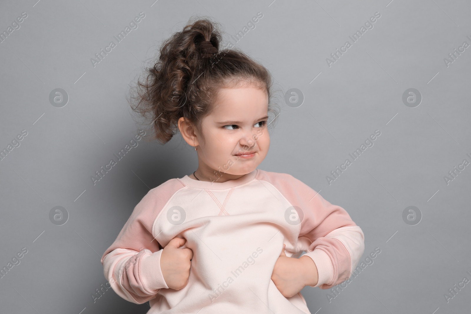 Photo of Adorable child. Portrait of cute girl on grey background