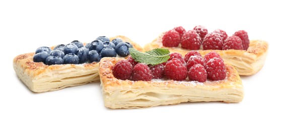 Photo of Tasty puff pastries with berries isolated on white