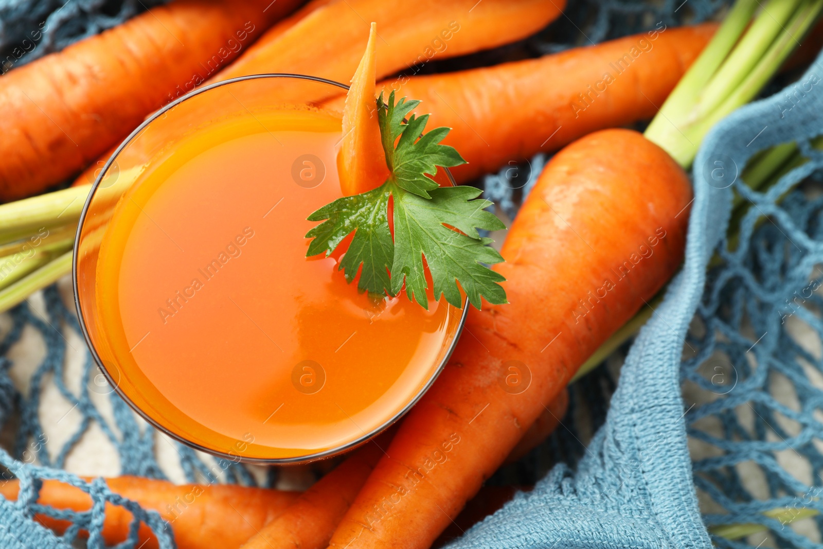 Photo of Healthy juice in glass and fresh carrot on table, top view