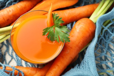 Healthy juice in glass and fresh carrot on table, top view